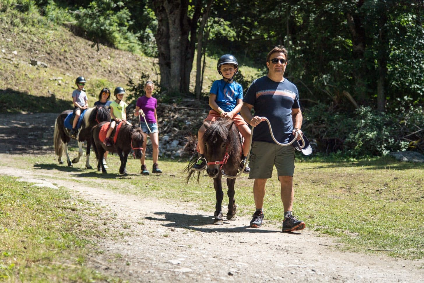 Une famille fait une balade en poney à valloire en été