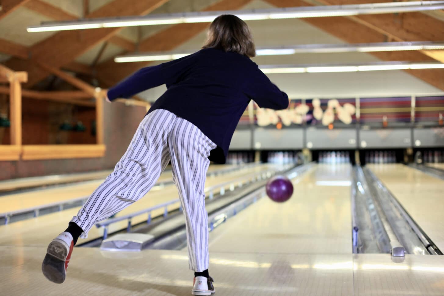 Une jeune fille lance sur boule de bowling sur la piste à Valloire